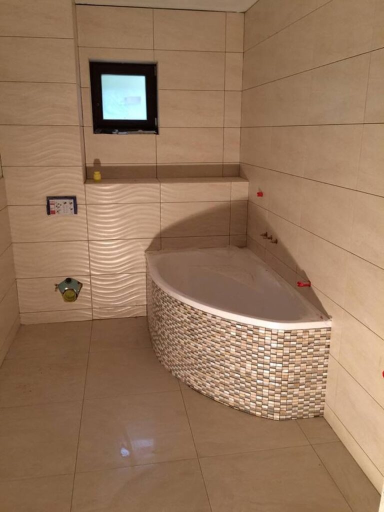 Bathroom with corner bathtub and tiled walls